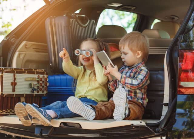 kinderen in auto met koffers