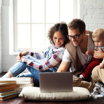 Jong gezin gelukkig in nieuwe woning op de laptop finzie website
