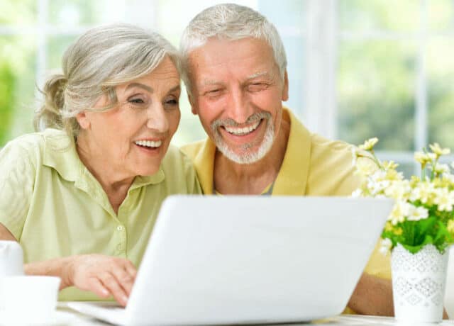 Man en vrouw die naar laptop lachen