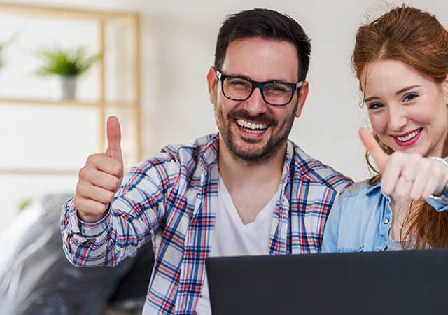 Man en vrouw steken duim op naar laptop